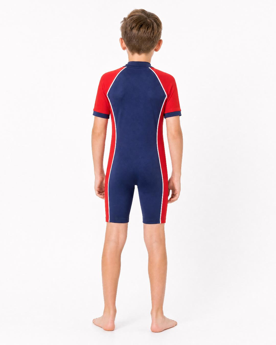 Back of 8 year old boy wearing short sleeve UV swimsuit UPF 50+ - navy red