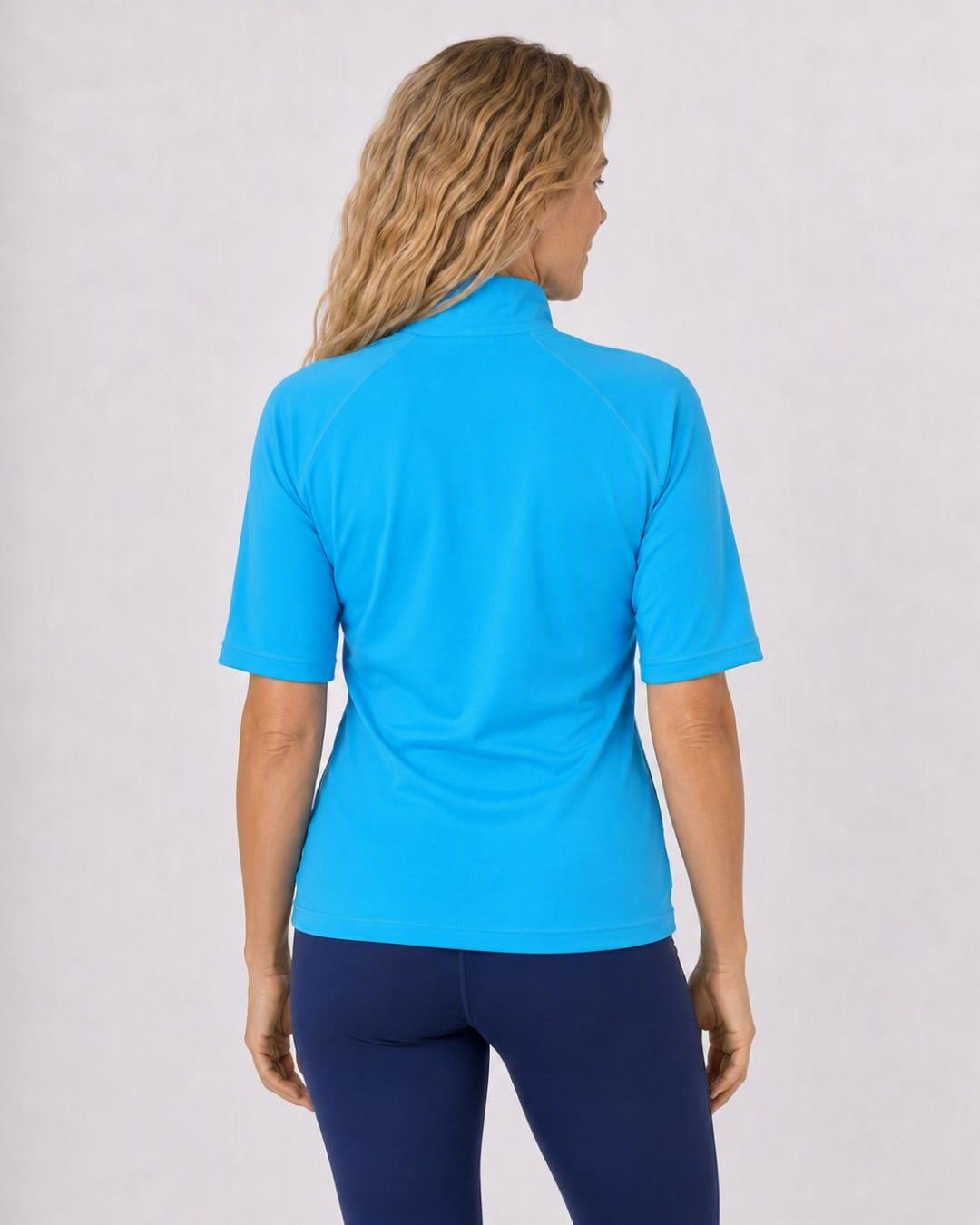 Back of woman wearing a blue zipped UV swim shirt UPF 50+ on a white background