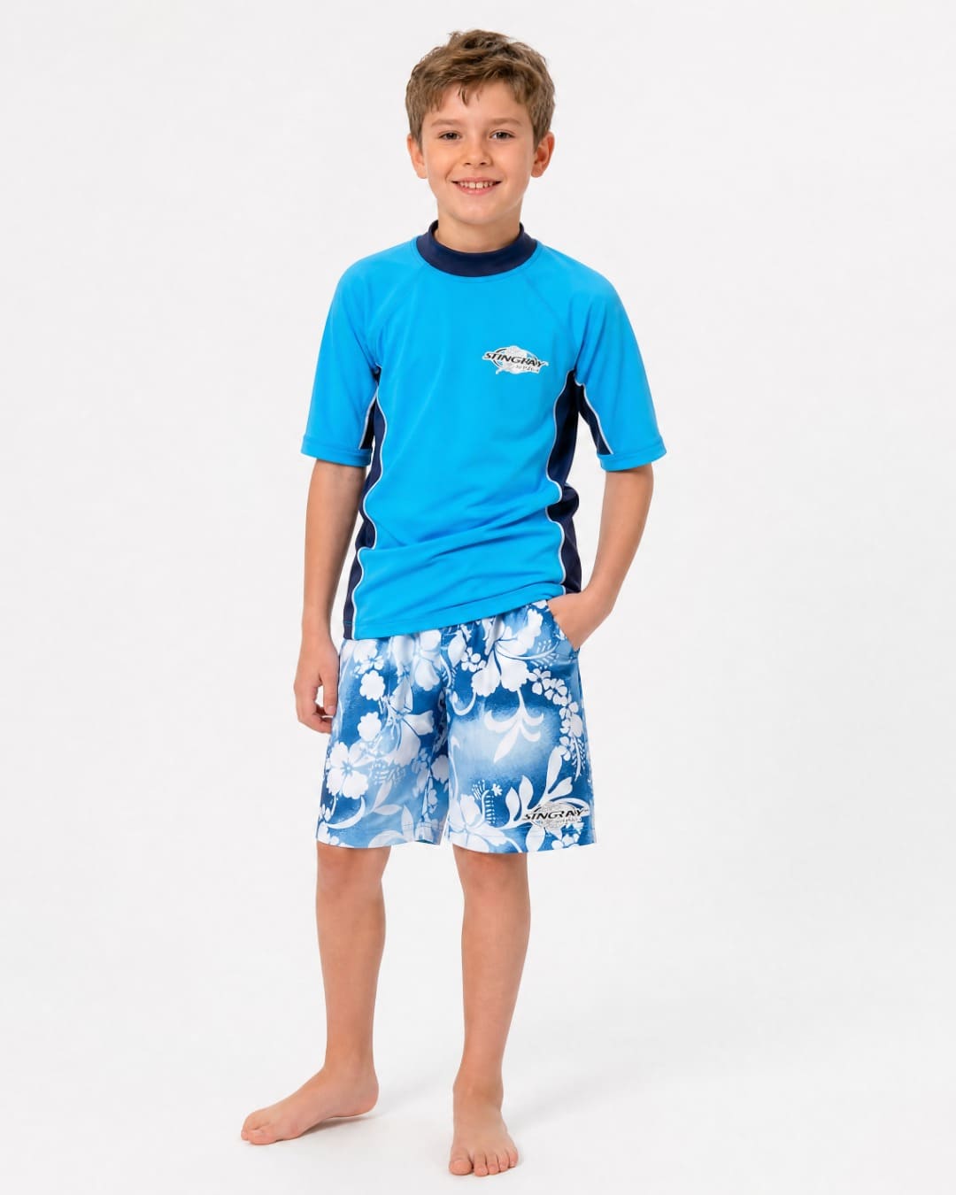 Boy wearing blue hawaii Stingray UV board shorts UPF 50+ in studio