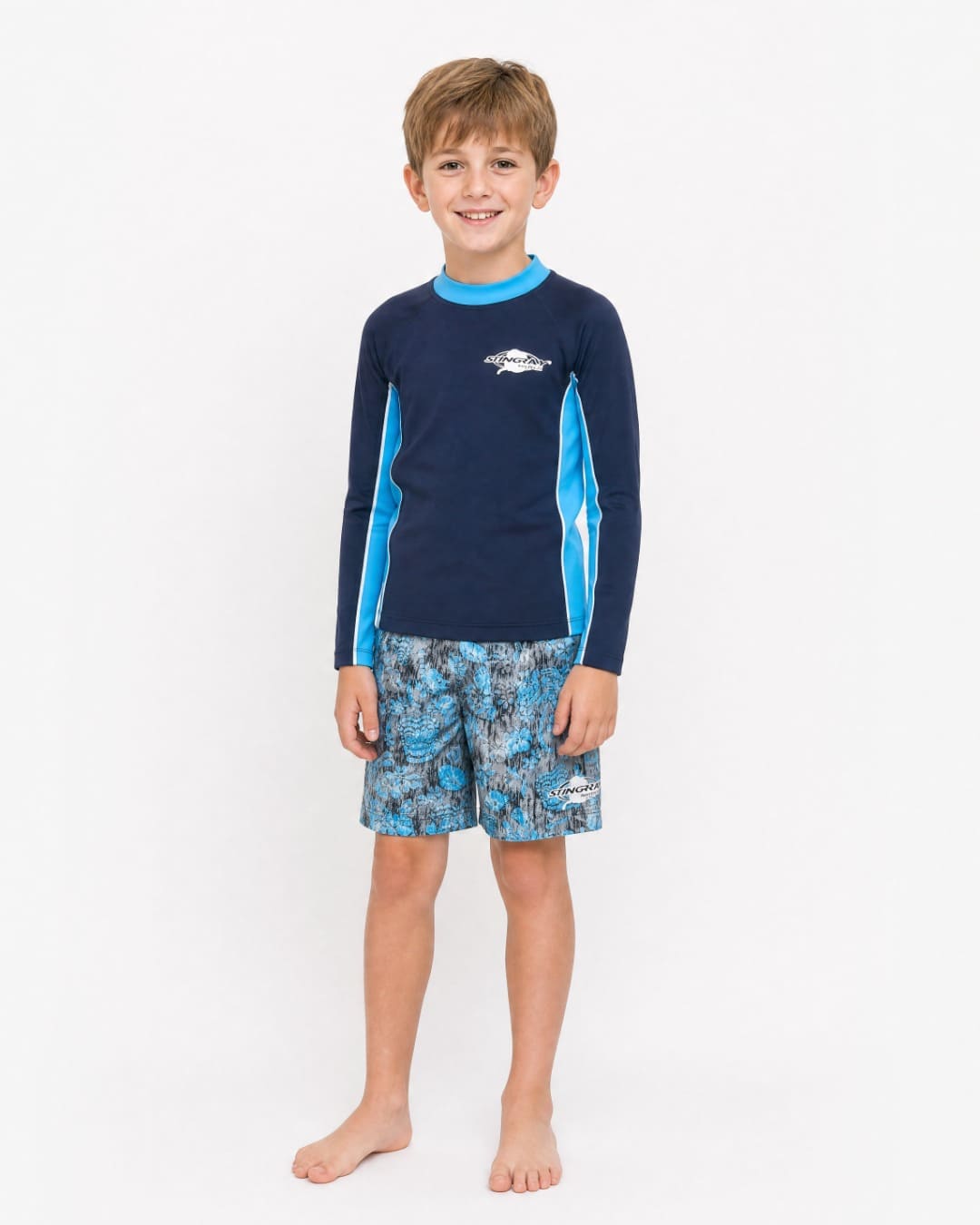 Boy wearing blue tribal Stingray UV board shorts UPF 50+ in studio