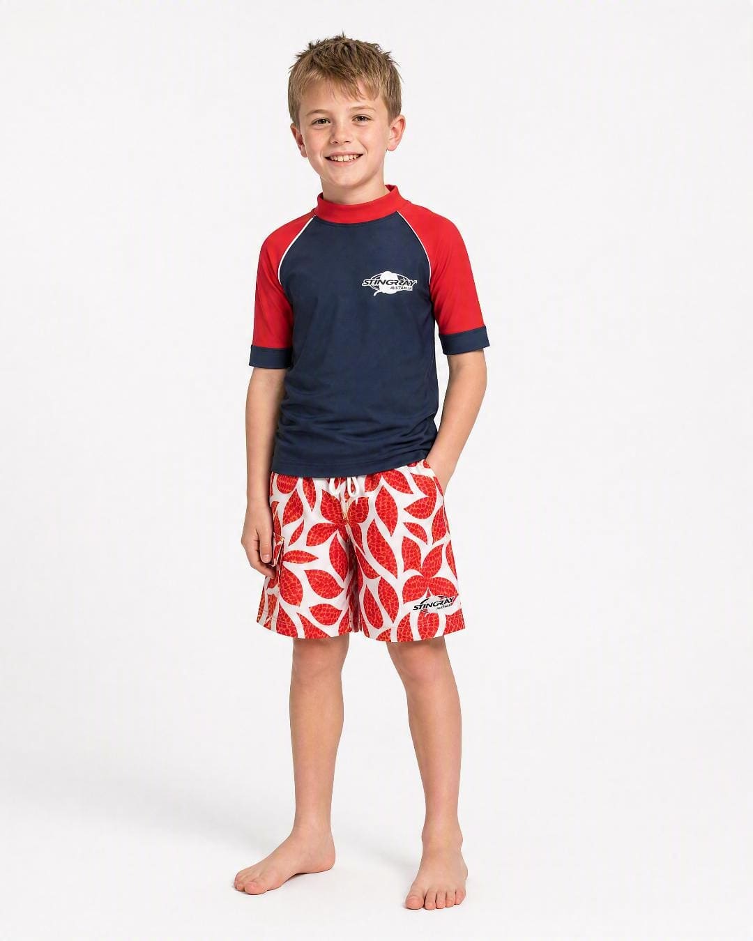 Boy wearing red hawaii Stingray UV board shorts UPF 50+ in studio