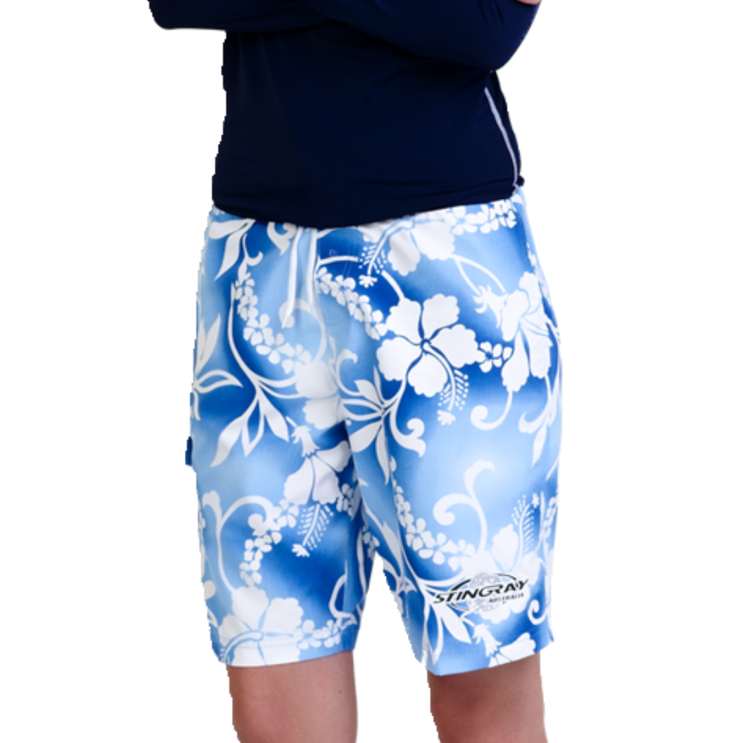 Woman wearing the Stingray Unisex  Australian-designed tribal blue Hawaii Board Shorts with UPF 50+ sun protection, featuring a side pocket and drawstring.