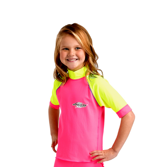 Toddler girl wearing pink and yellow Stingray Kids' Unisex Short Sleeve Rash Shirt in durable, soft chlorine-resistant fabric. This swim shirt is rated UPF 50+ to provide the best UV sun protection.