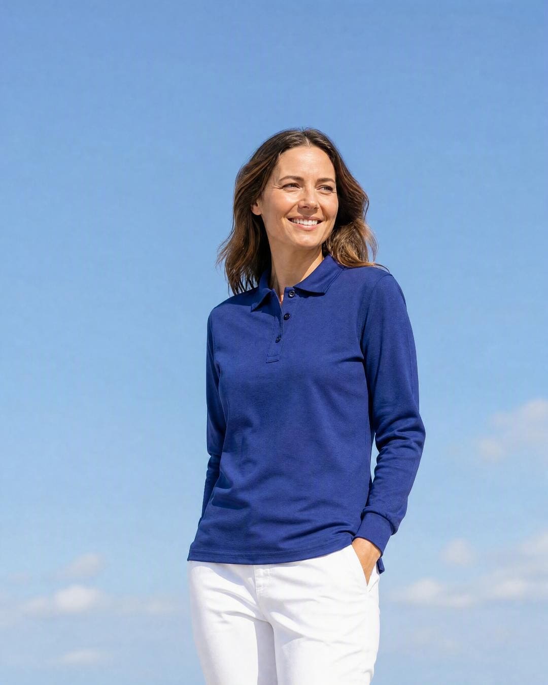 Lifestyle image of a woman wearing an spf golf shirt standing on the golf course