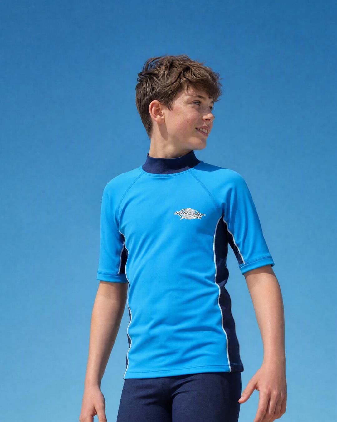 Lifestyle of 10 year old boy wearing short sleeve uv rash vest UPF 50+ - azure navy