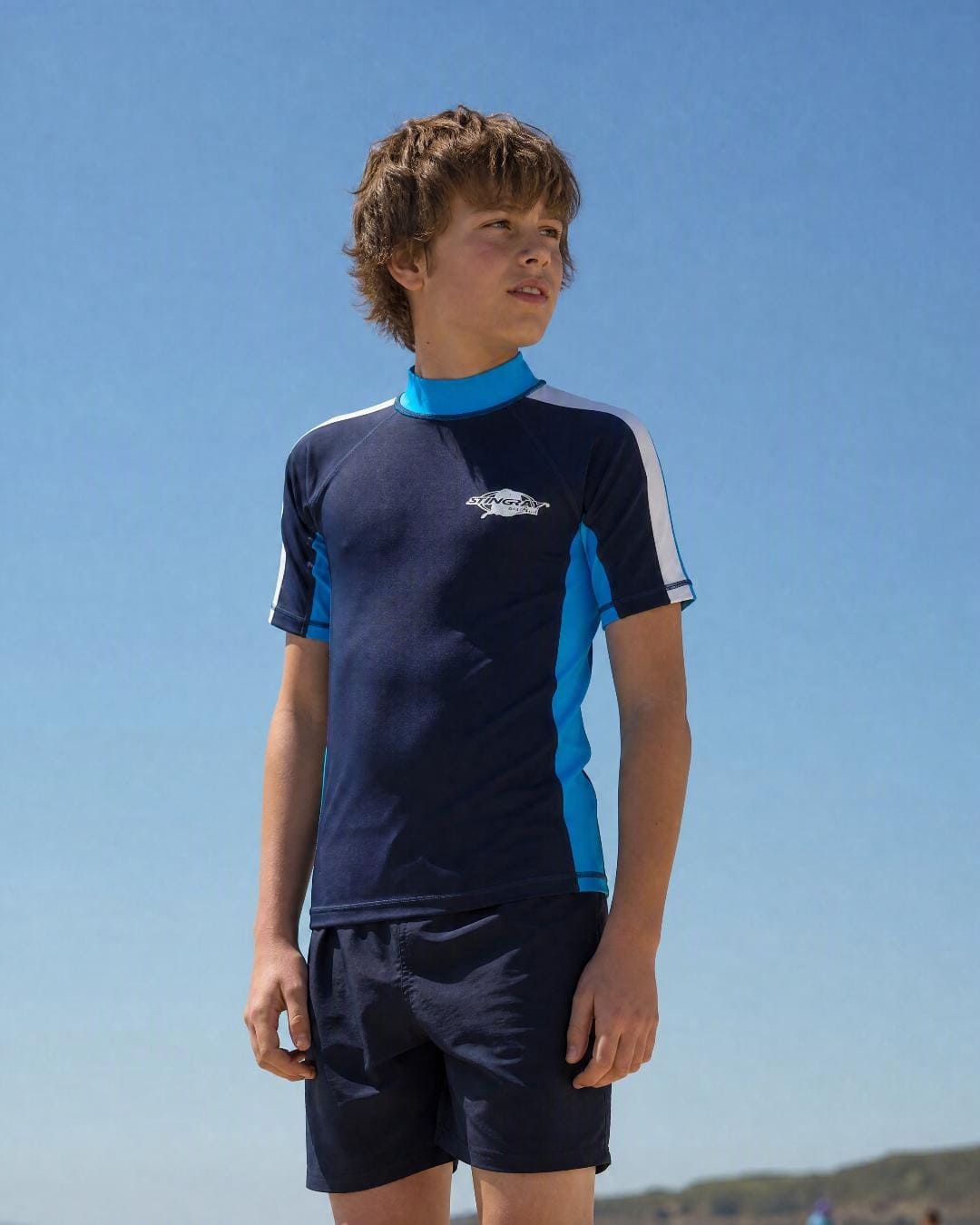 Lifestyle of 10 year old boy wearing short sleeve uv rash vest UPF 50+ - navy azure white