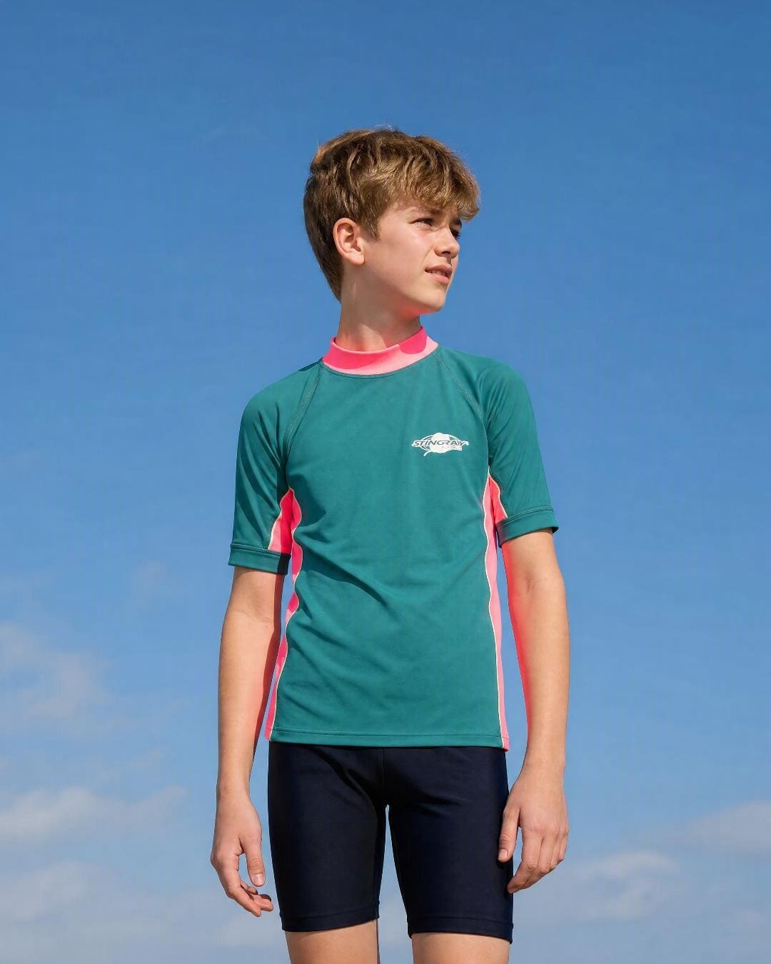 Lifestyle of 12 year old boy wearing short sleeve uv rash vest UPF 50+ - teal pink