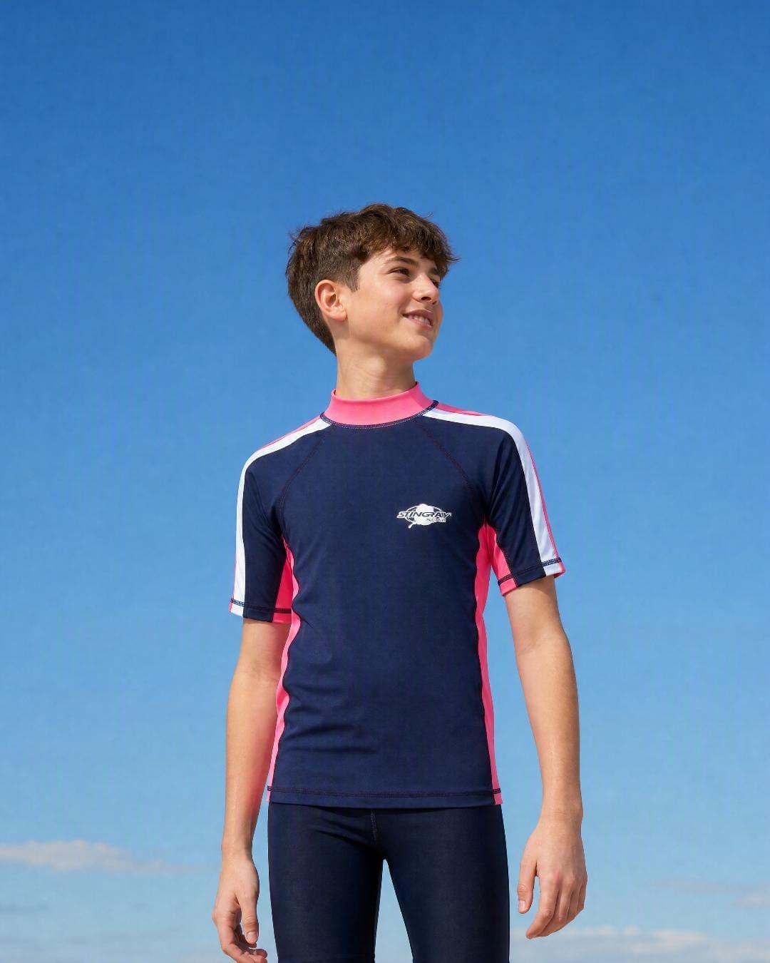 Lifestyle of 13 year old boy wearing short sleeve uv rash vest UPF 50+ - navy pink white