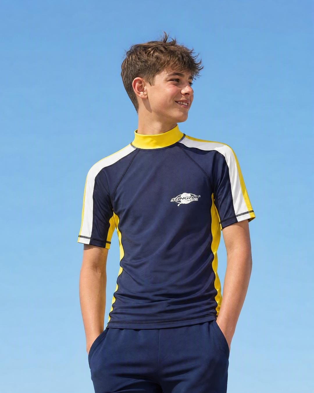 Lifestyle of 13 year old boy wearing short sleeve uv rash vest UPF 50+ - navy yellow white