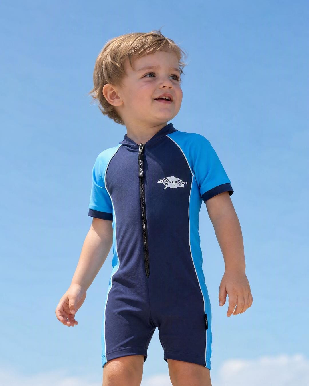 Lifestyle of 2 year old toddler wearing short sleeve UV sunsuit - navy azure