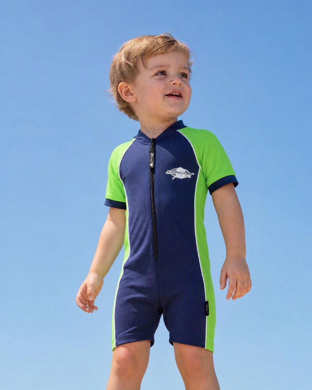 Lifestyle of 2 year old toddler wearing short sleeve UV sunsuit - navy green