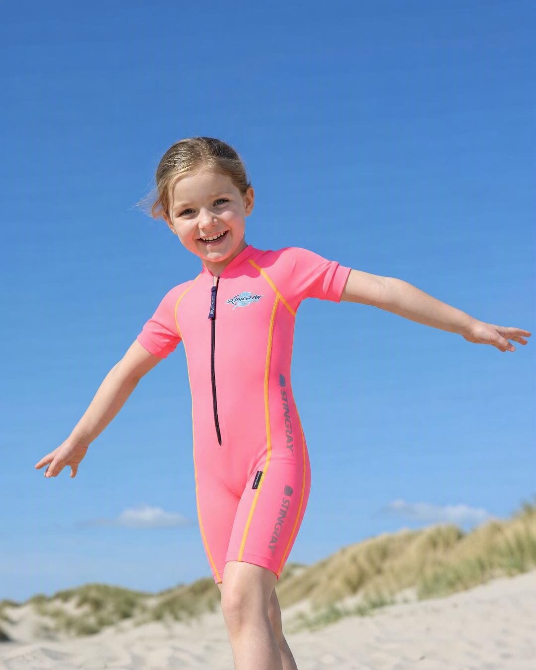 Lifestyle of 6 year old girl wearing short sleeve UV swimsuit UPF 50+ - pink