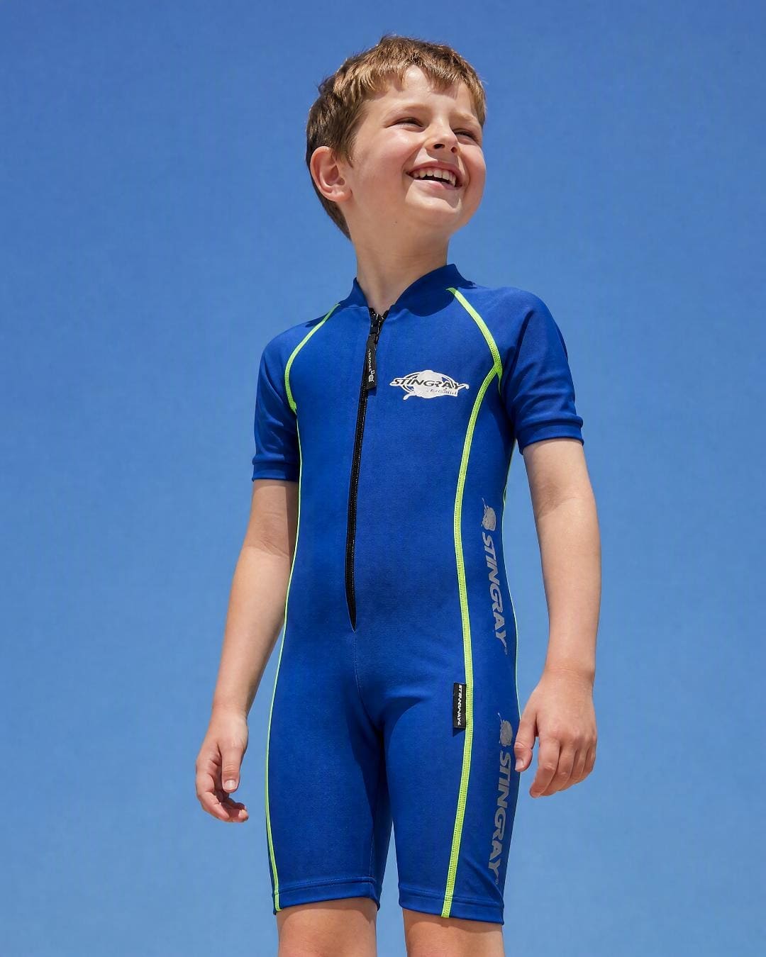 Lifestyle of 8 year old boy wearing short sleeve UV swimsuit UPF 50+ - blue