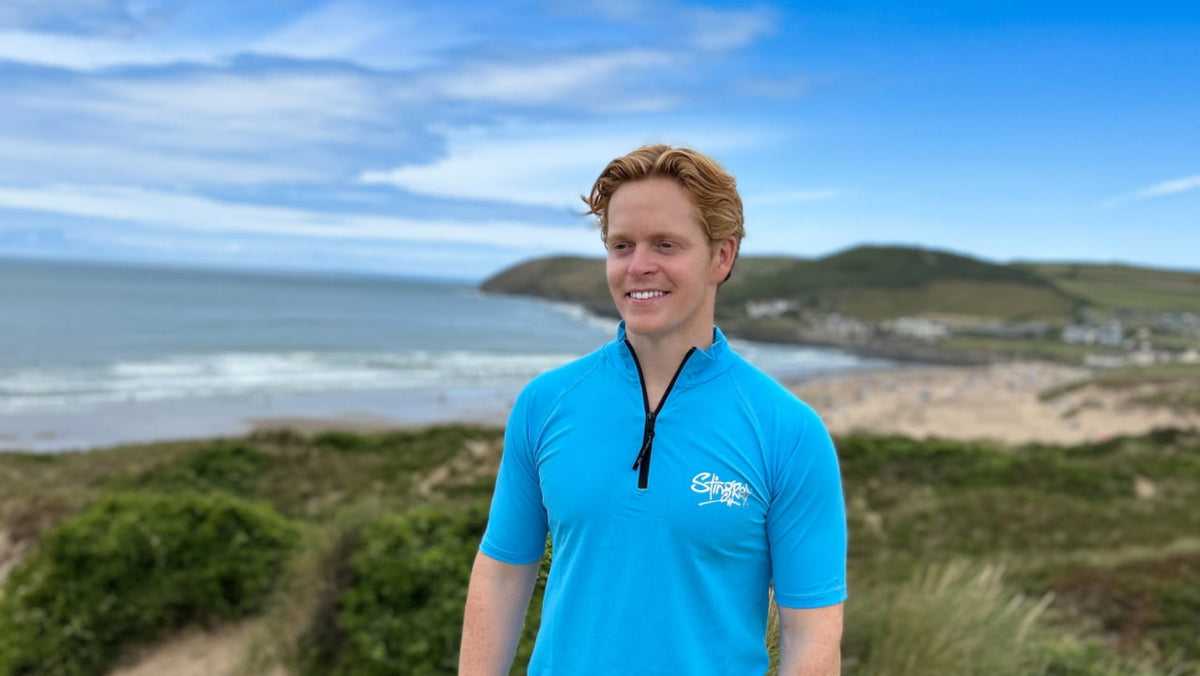 Man in a blue UPF 50+ swim shirt on a UK beach