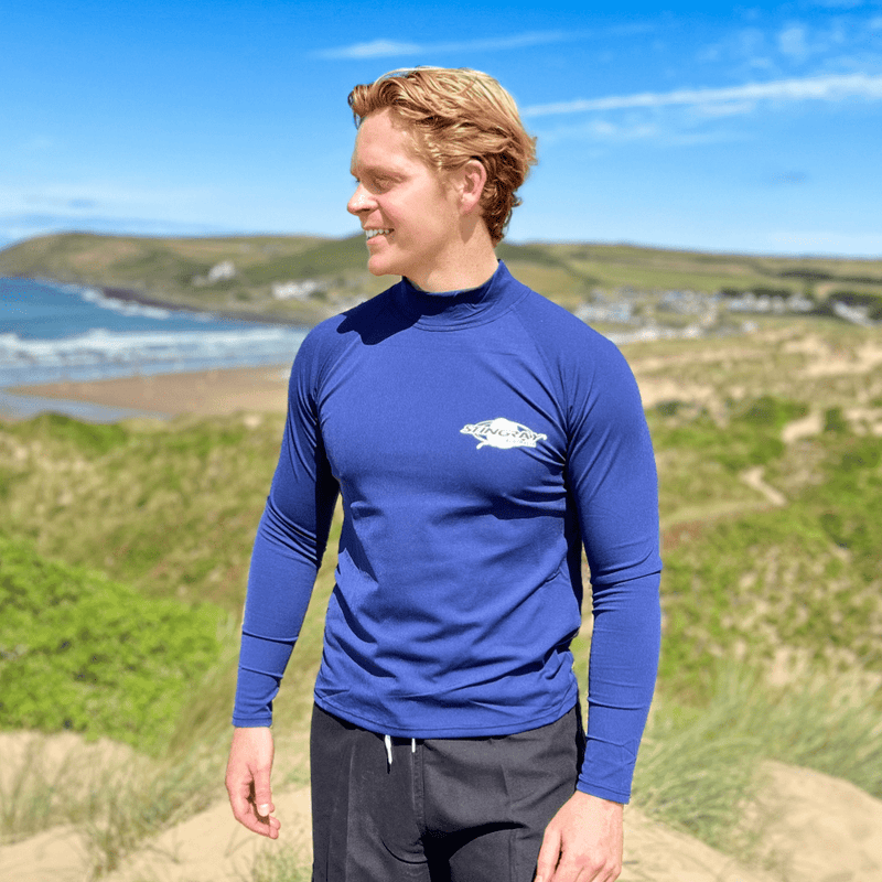 Man wearing UV swim shirt standing on the beach