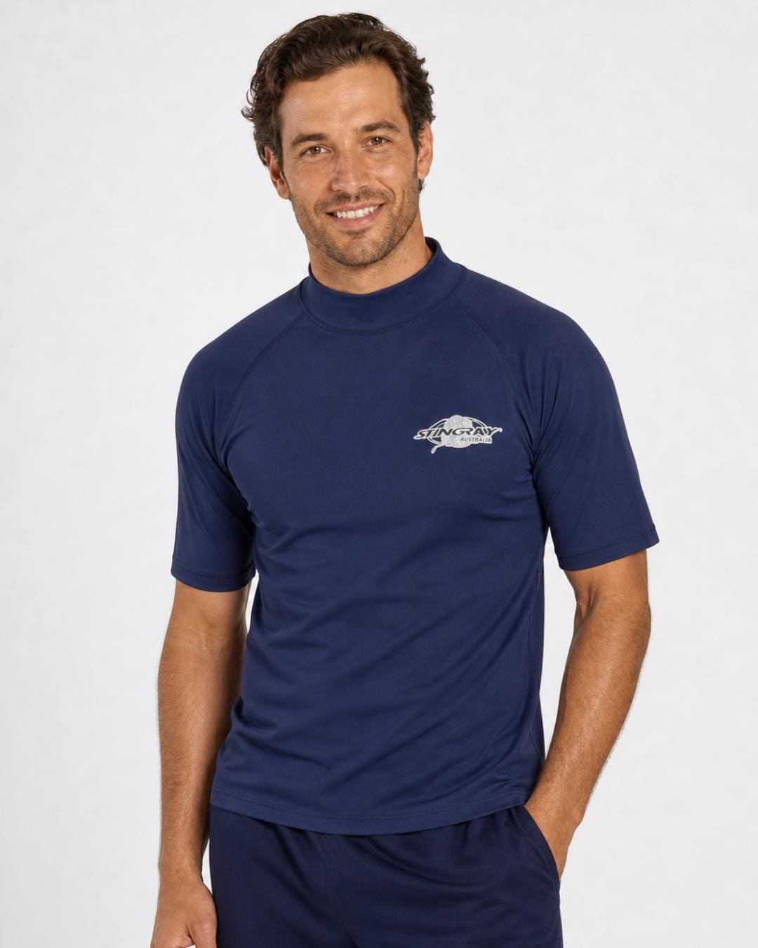 Man wearing navy blue UV rash top UPF 50+ in a white studio