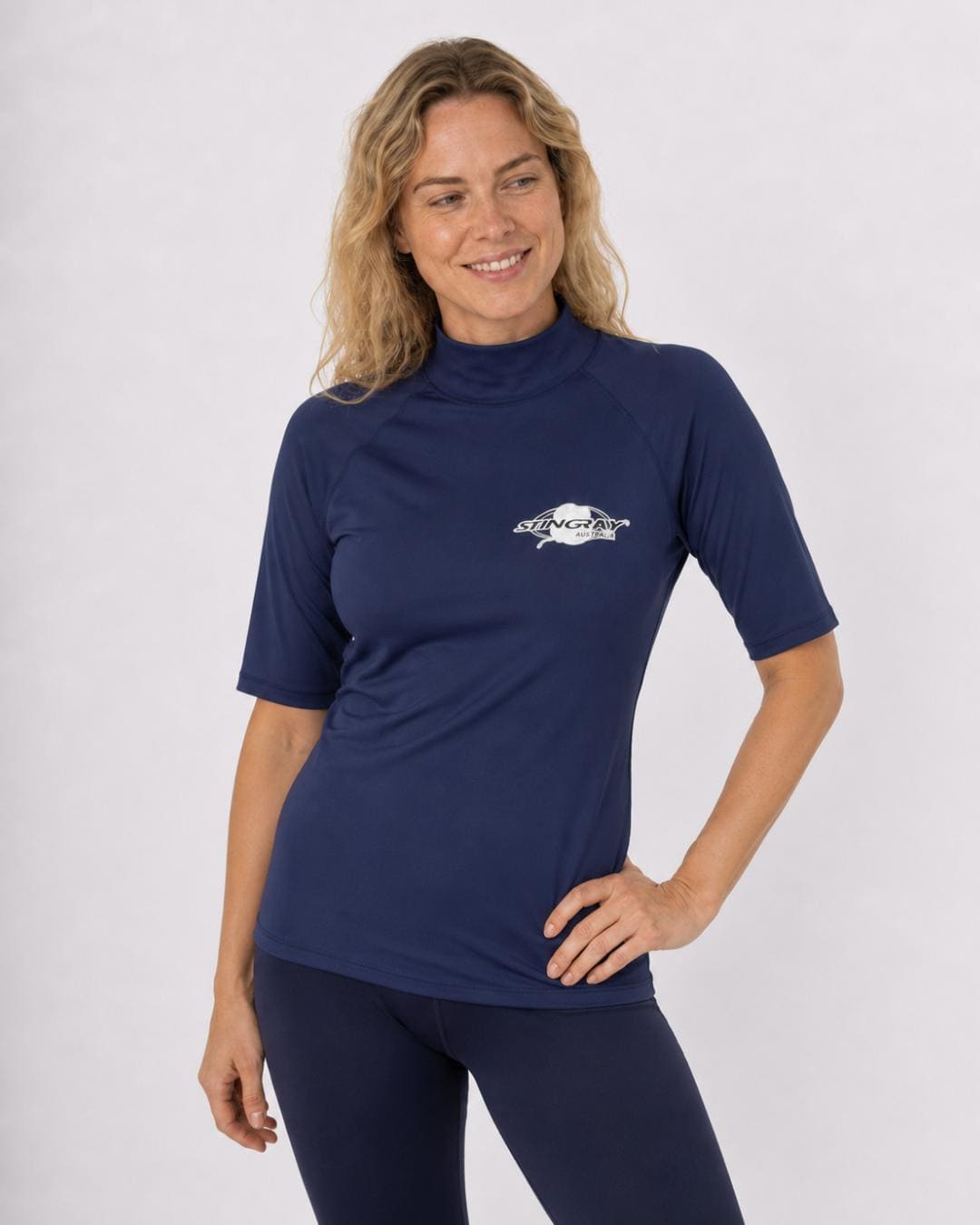 Woman wearing an navy blue UV swim shirt UPF 50+ on a white background