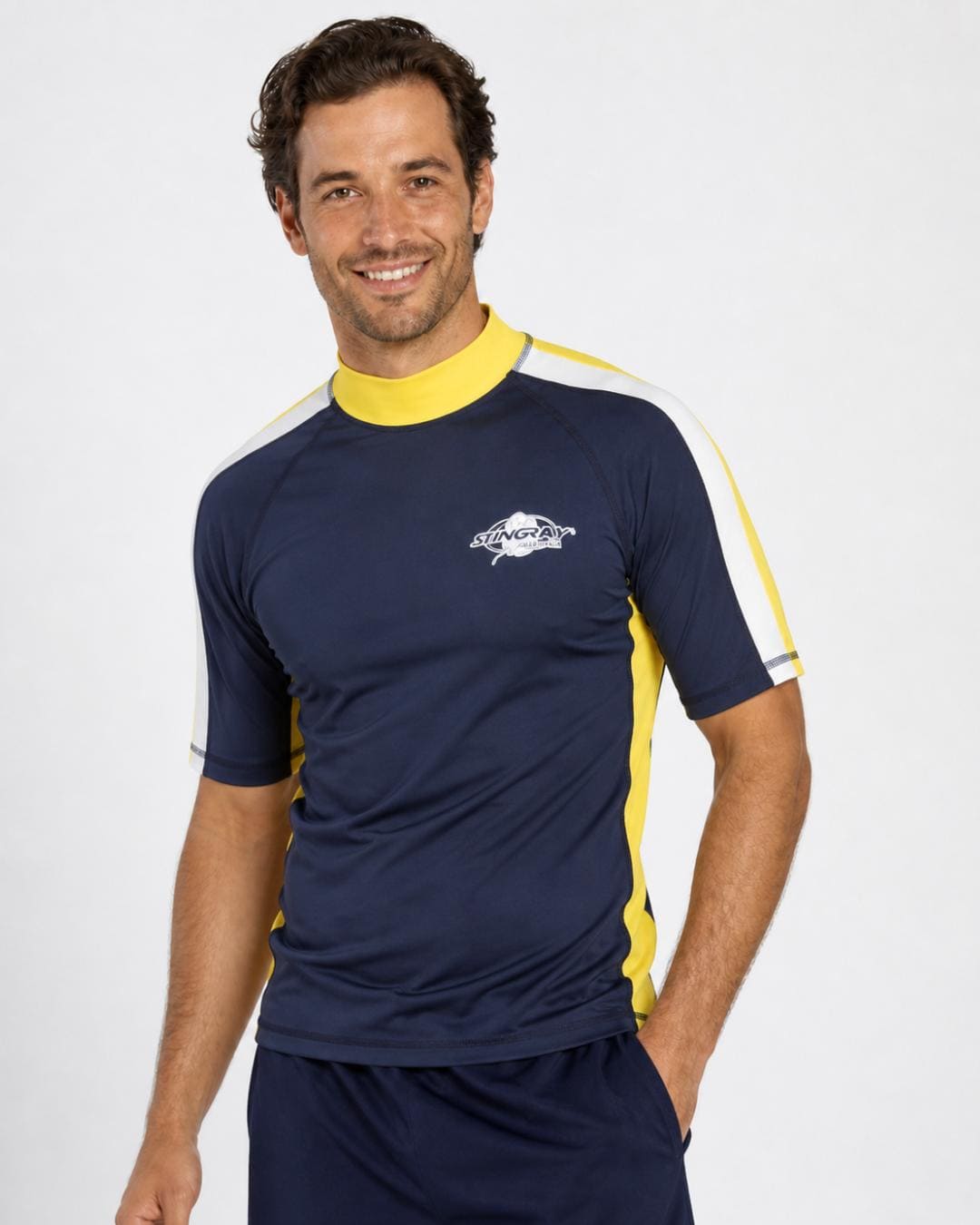 Man wearing navy and yellow and white UV rash shirt UPF 50+ in a white studio