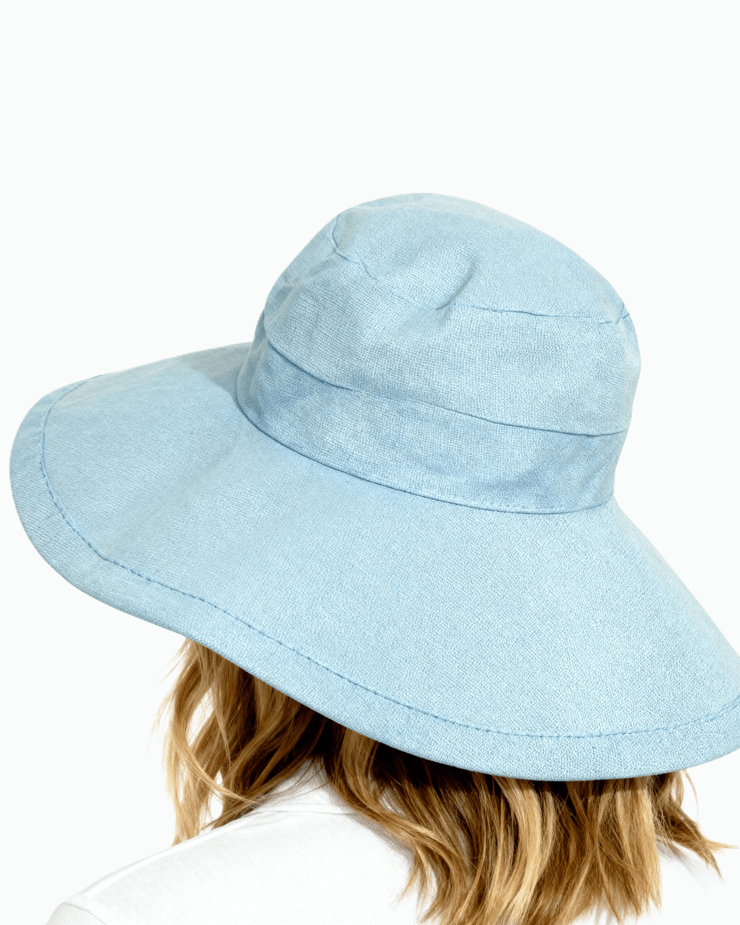 Behind angle of a woman wearing light blue Stingray Sun Hat with 4-inch wide brim and UPF 50+ sun protection. 