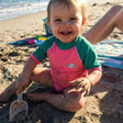 Review pic: baby in UPF 50+ rash shirt sitting on the beach