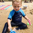 Review pic: child wearing UPF 50+ swim top playing on the beach
