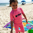 Review pic: child wearing UPF swim leggings standing on the beach