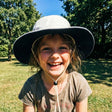 Review pic: girl wearing UV cricket hat in a field