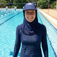 Review pic: swim teacher wearing UPF 50+ nomad sun cap in the water