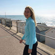 Review pic: woman laughing whilst walking along the promenade wearing a UPF 50+ long-sleeve jacket
