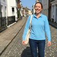 Review pic: woman laughing whilst wearing a long sleeve UV protection polo shirt in light blue 