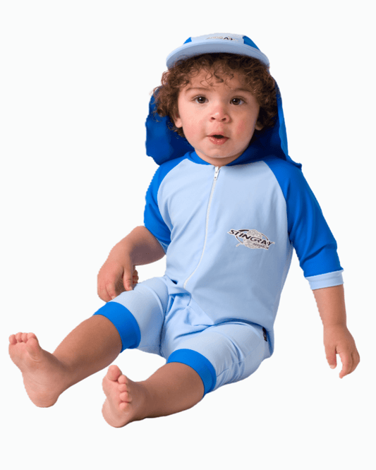Baby wearing a blue and white sun suit on a white background