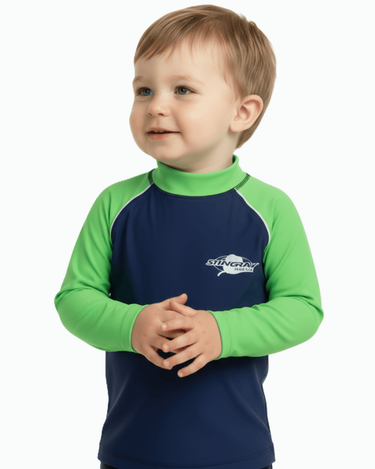 Toddler wearing a navy and green long-sleeve UV swim shirt with a visible Stingray logo on a white background