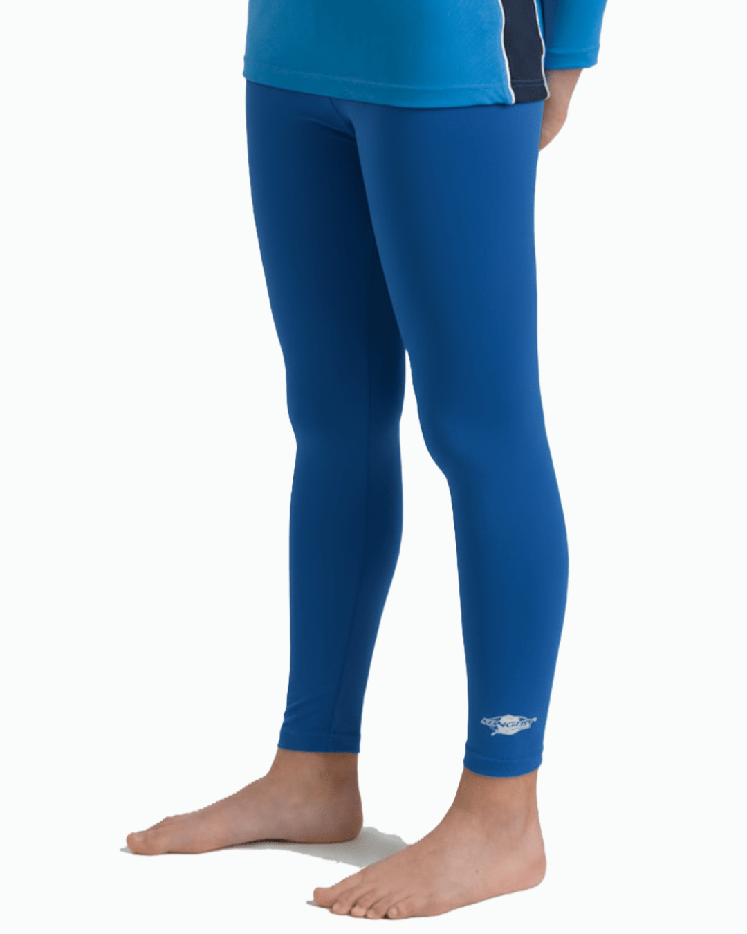 Toddler wearing ocean blue sun protection leggings with a Stingray logo on a white background