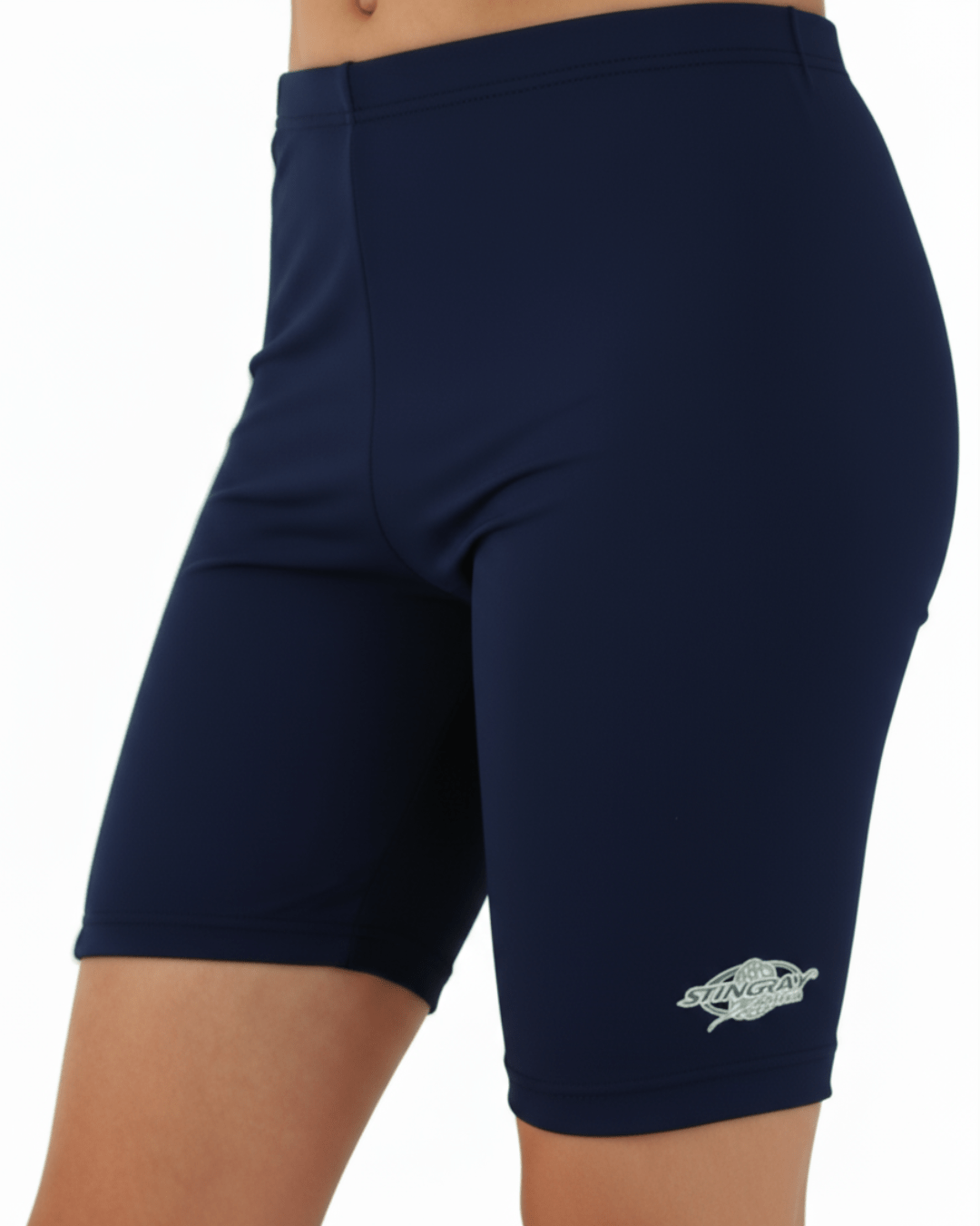 Toddler wearing navy blue sun protection swim shorts with a Stingray logo on a white background