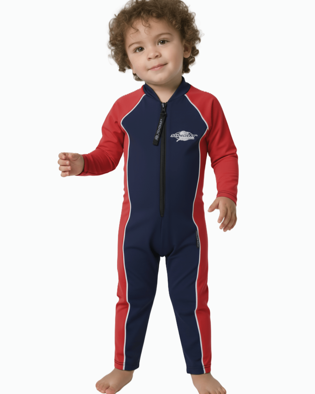 Toddler wearing a red and navy blue UV swimsuit on a white background