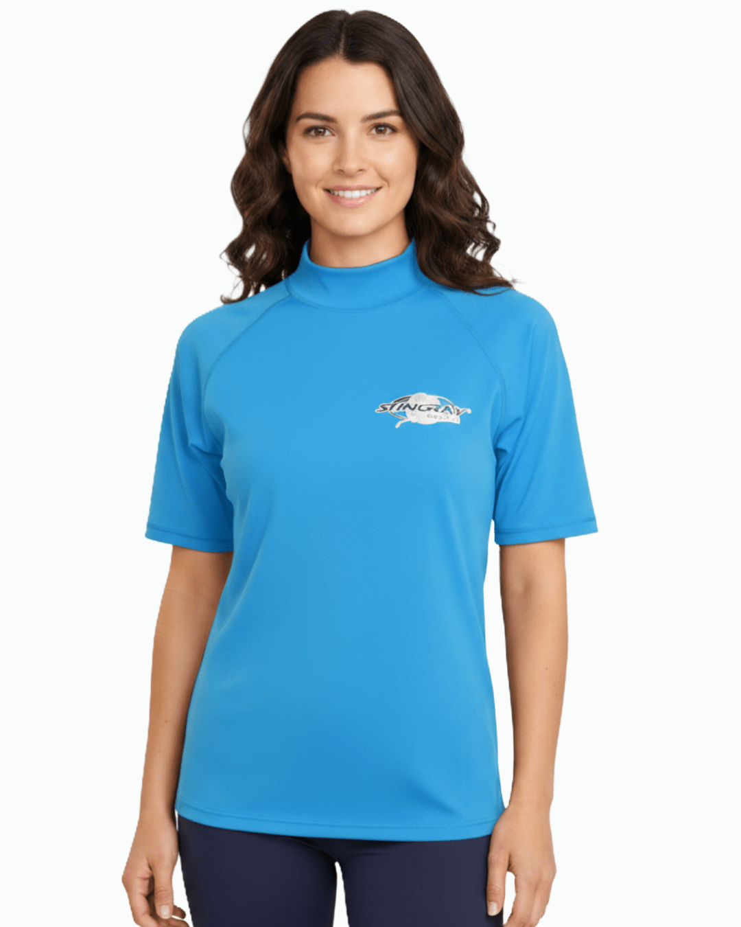 Woman wearing azure blue Stingray adult short sleeve rash shirt with UPF 50+ sun protection, made from chlorine-resistant fabric for outdoor and water activities.