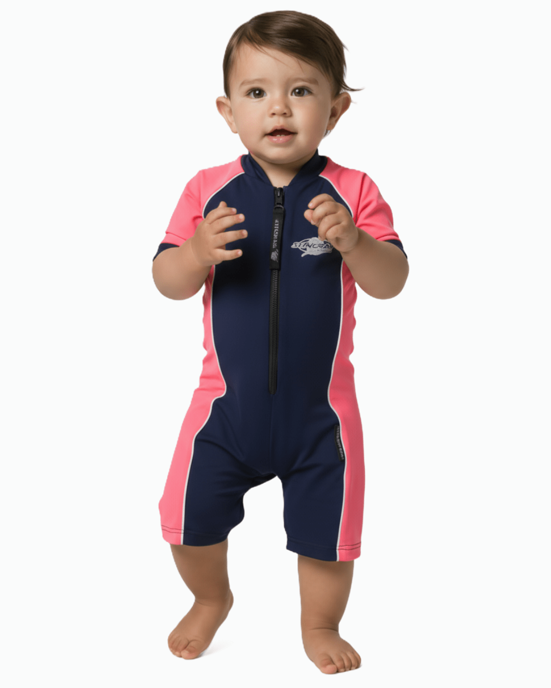 Baby wearing a navy and pink UPF 50+ swimsuit on a white background