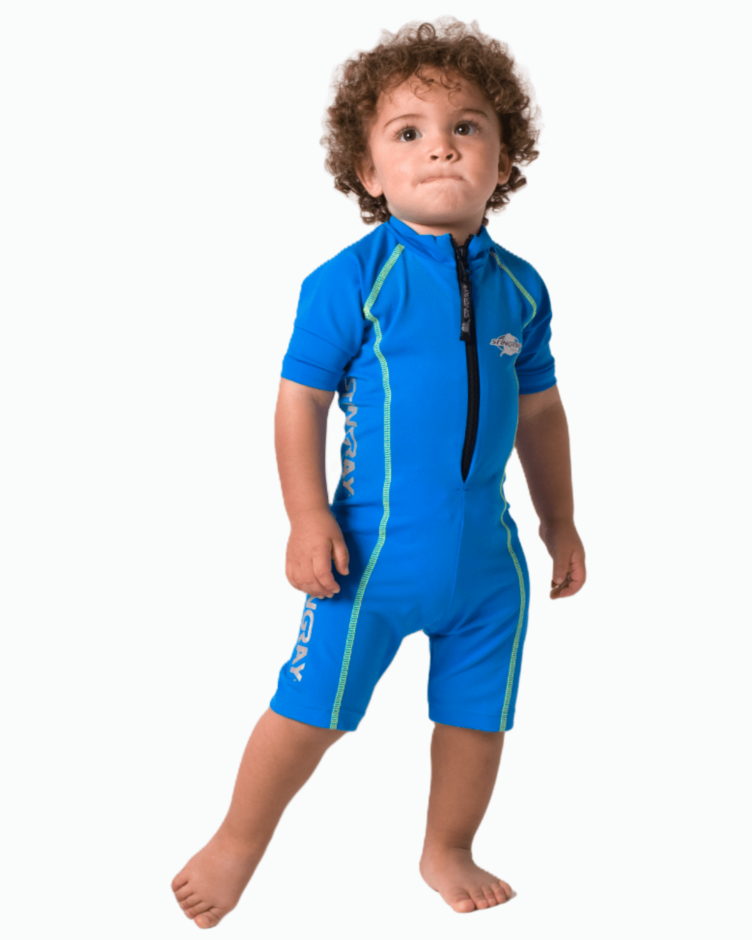 Toddler wearing a blue one piece UV swimsuit with green stitching on a white background
