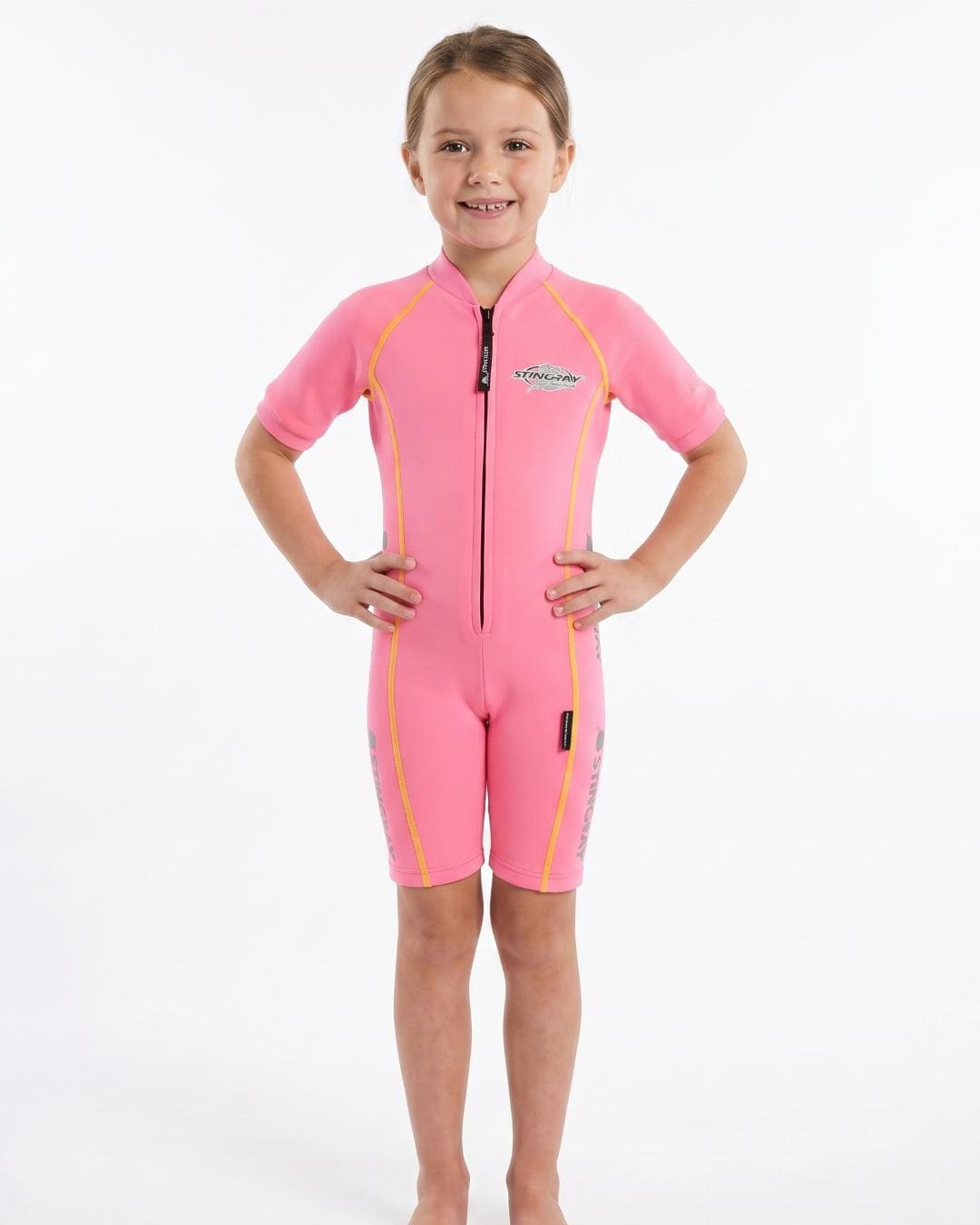 6 year old girl wearing a pink sun protection swimsuit with short sleeves on a white background