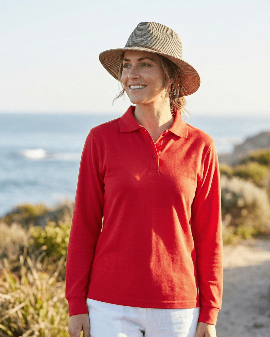 Woman wearing long sleeve UV polo shirt standing on a coastal path