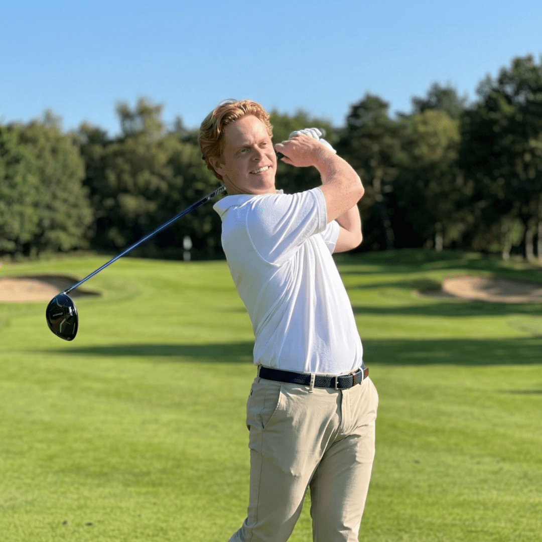 Man wearing a white UV polo shirt and chino trousers playing golf.