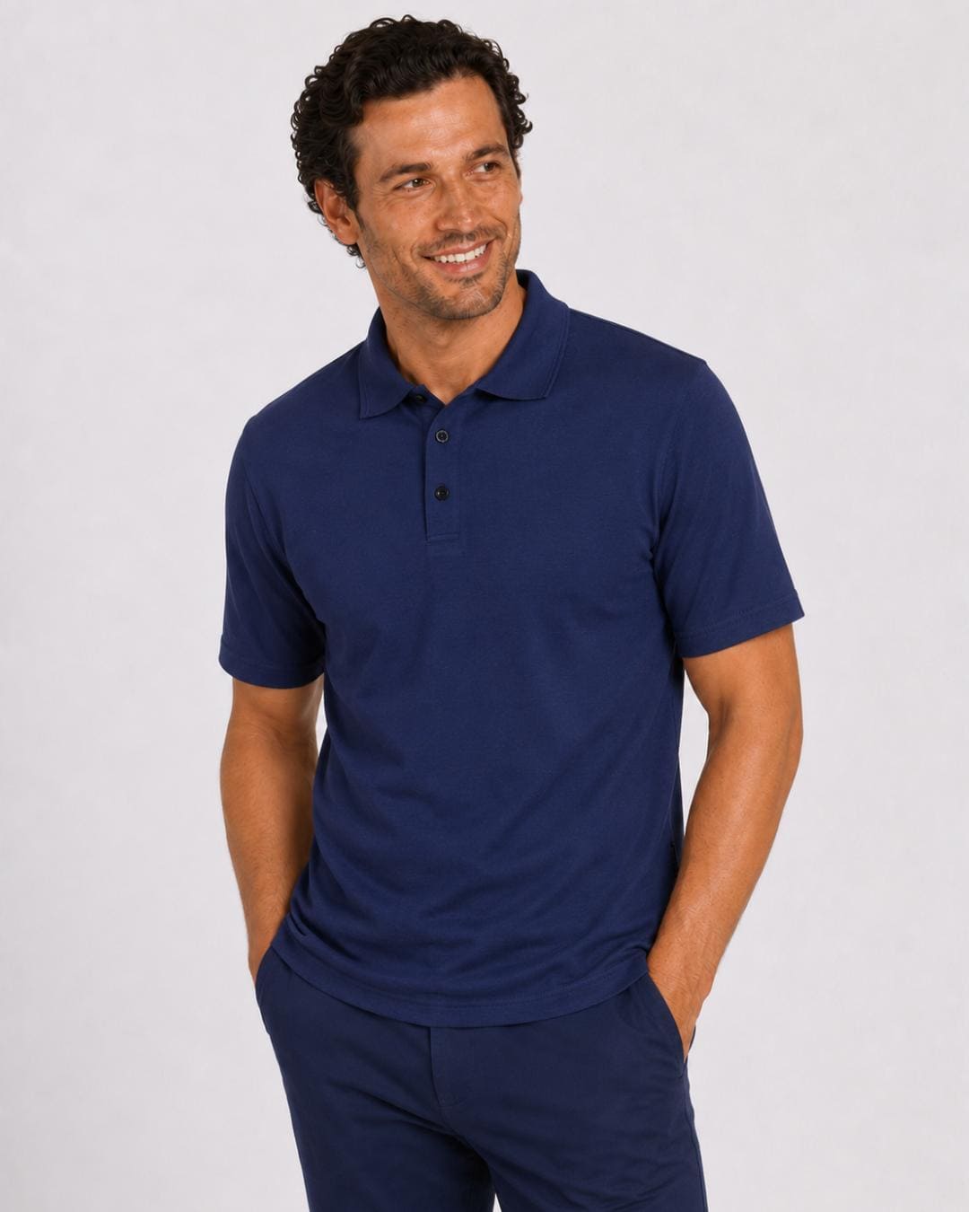 Man wearing a short-sleeve navy UV polo shirt and dark pants on a light grey background