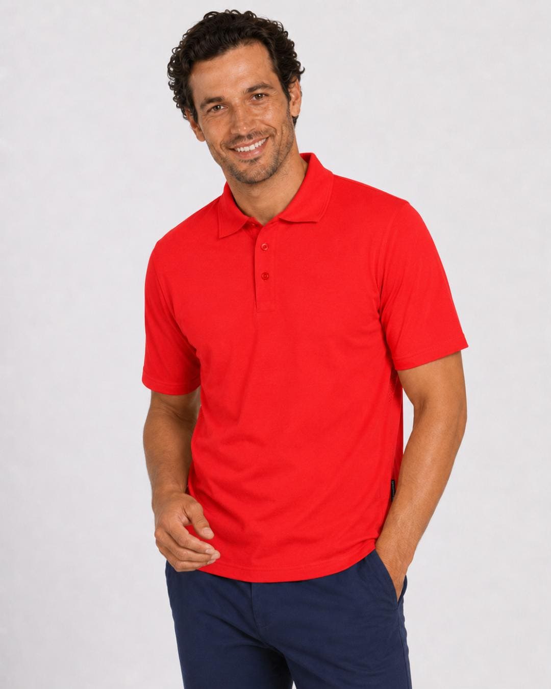 Man wearing a short-sleeve red UV polo shirt and dark pants on a light grey background
