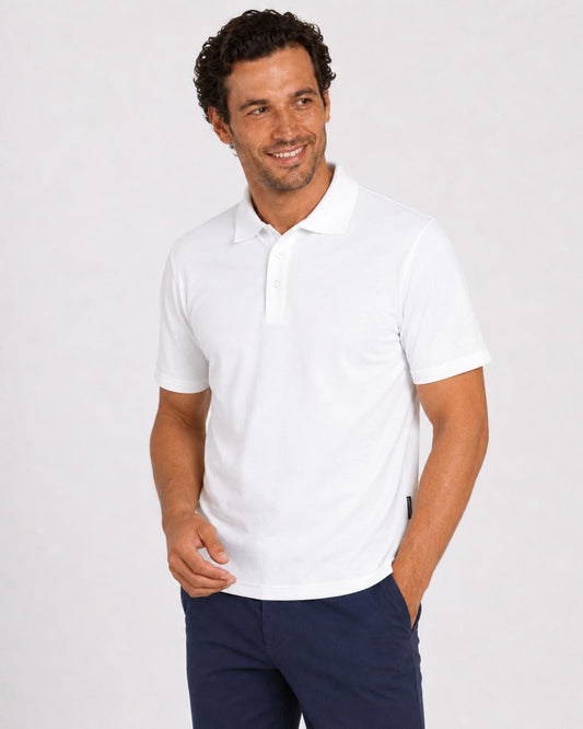 Man wearing a short-sleeve white UV polo shirt and dark pants on a light grey background