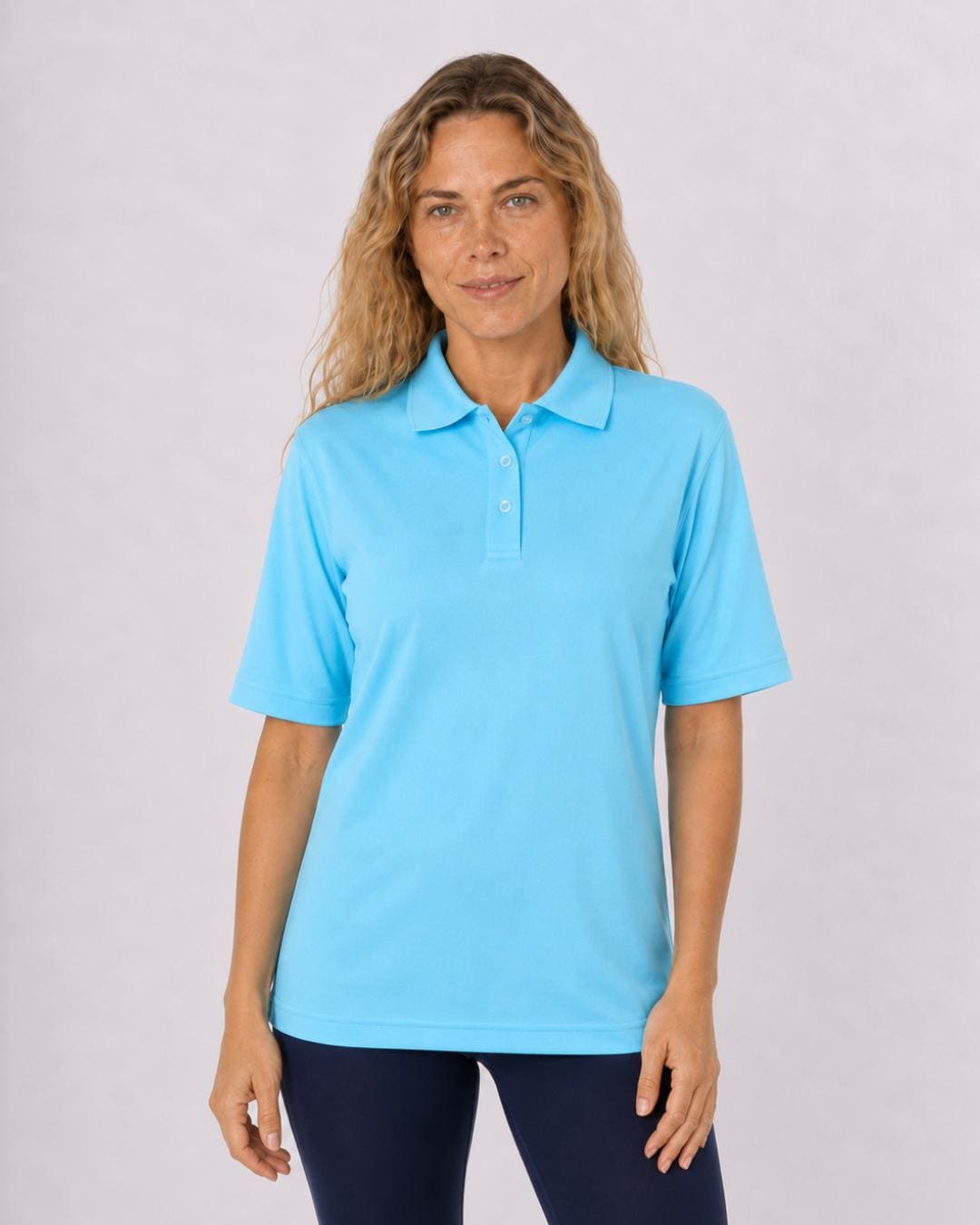 Woman wearing a ice blue short sleeve UV polo shirt and navy leggings on a white background