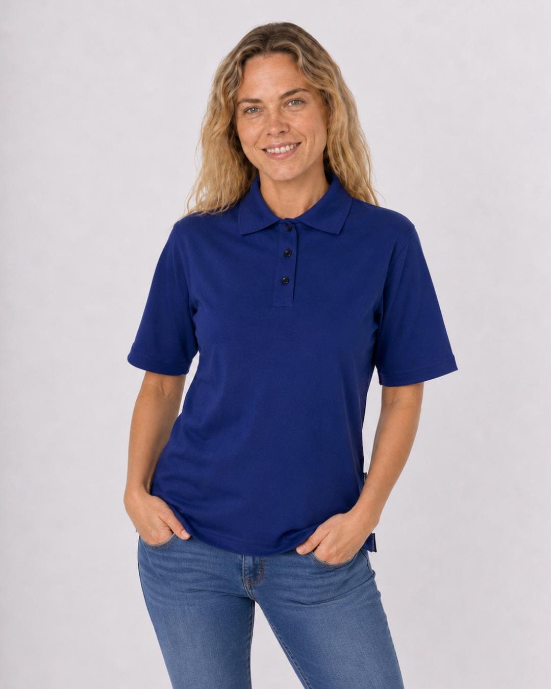 Woman wearing a navy blue short sleeve UV polo shirt and jeans on a white background