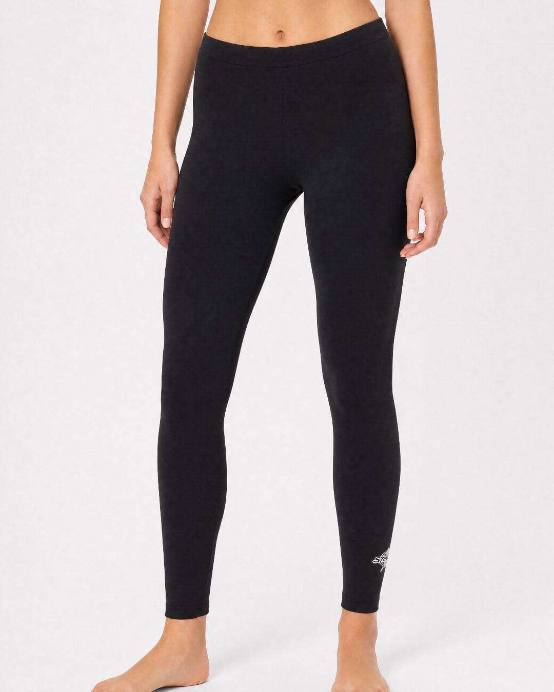Woman wearing UV swim leggings/tights UPF 50+ in black in a white studio