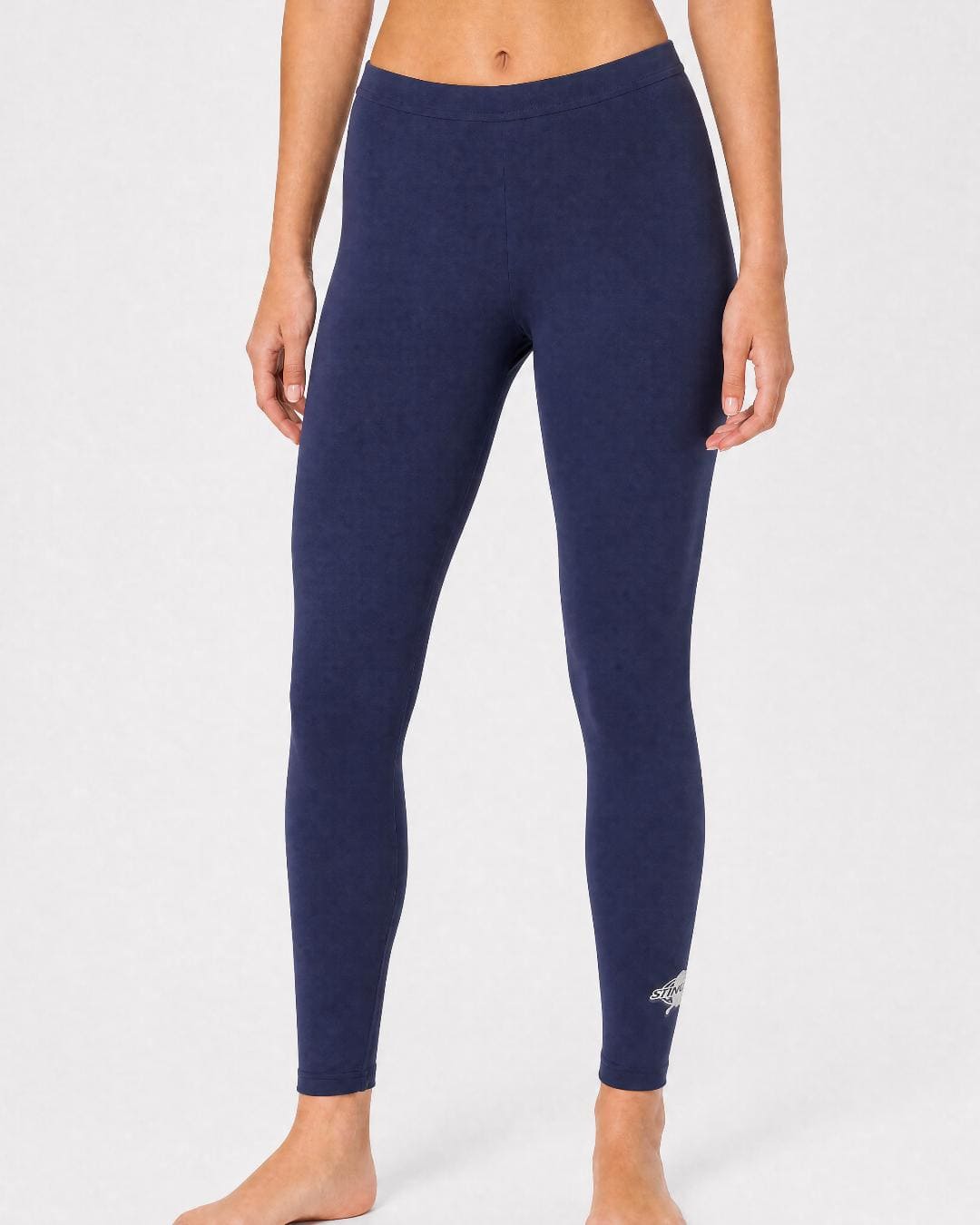 Woman wearing UV swim leggings/tights UPF 50+ in navy in a white studio