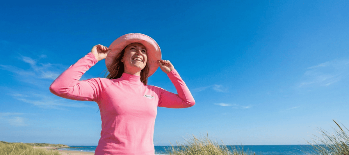 Woman in a pink UPF 50+ top and sun hat in bright sunshine