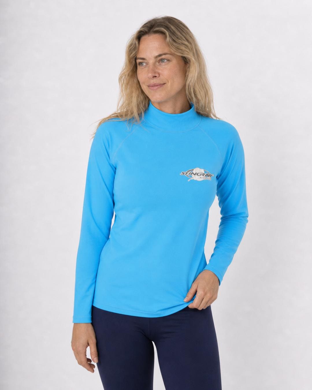 Woman wearing an azure blue long-sleeve UV swim shirt UPF 50+ on a white background